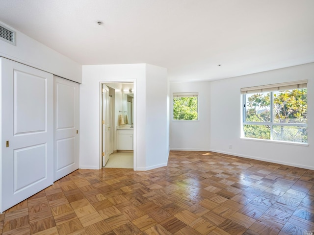 unfurnished bedroom with parquet flooring and ensuite bathroom