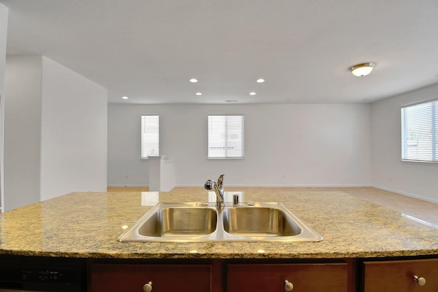 kitchen featuring sink, light stone countertops, and dishwasher