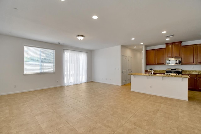 kitchen featuring a kitchen bar, range, light tile floors, and light stone counters