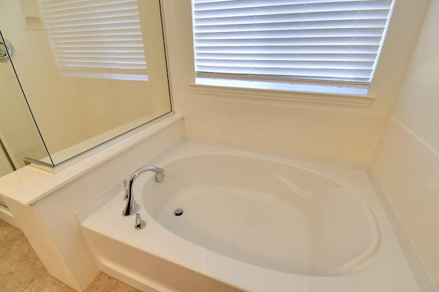 bathroom featuring tile floors and a bath to relax in