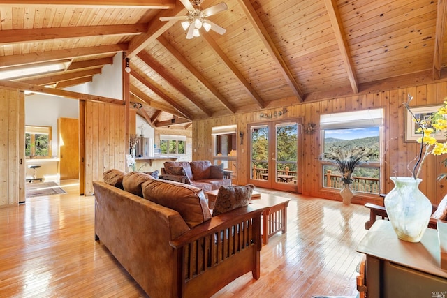 living room featuring wooden ceiling, wooden walls, light wood-type flooring, and beamed ceiling