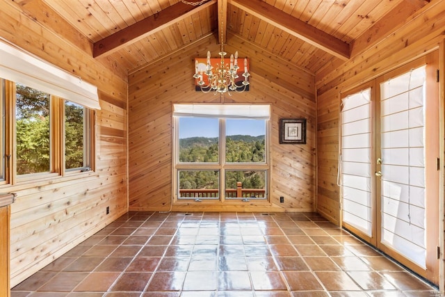 tiled empty room with beamed ceiling, wooden ceiling, a notable chandelier, and a wealth of natural light