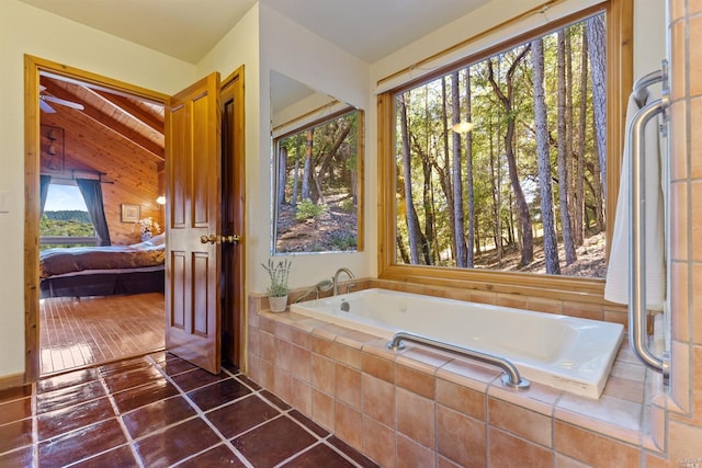 bathroom with a relaxing tiled bath, tile floors, and ceiling fan