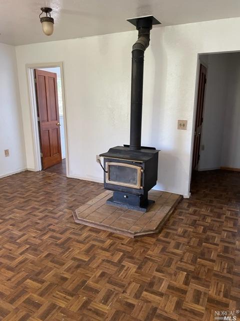 room details with dark parquet floors and a wood stove