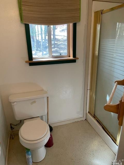 bathroom featuring walk in shower and toilet