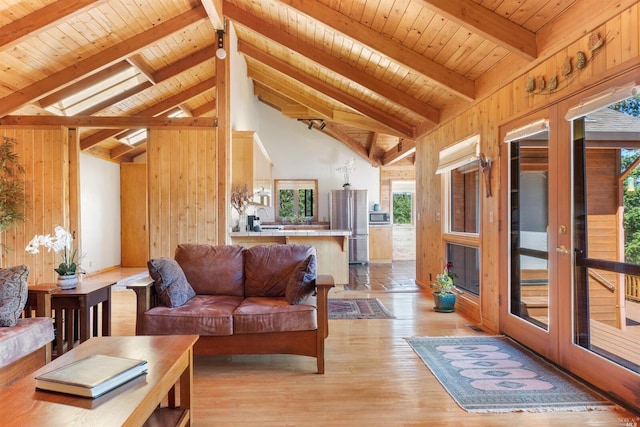 living room featuring beam ceiling, wood ceiling, wooden walls, and light wood-type flooring