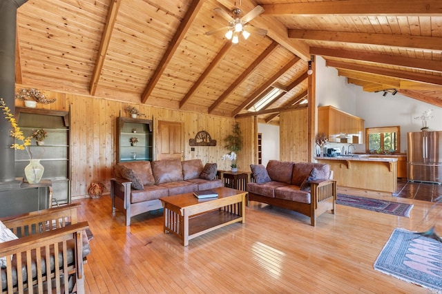 living room with wood walls, high vaulted ceiling, wooden ceiling, and beamed ceiling