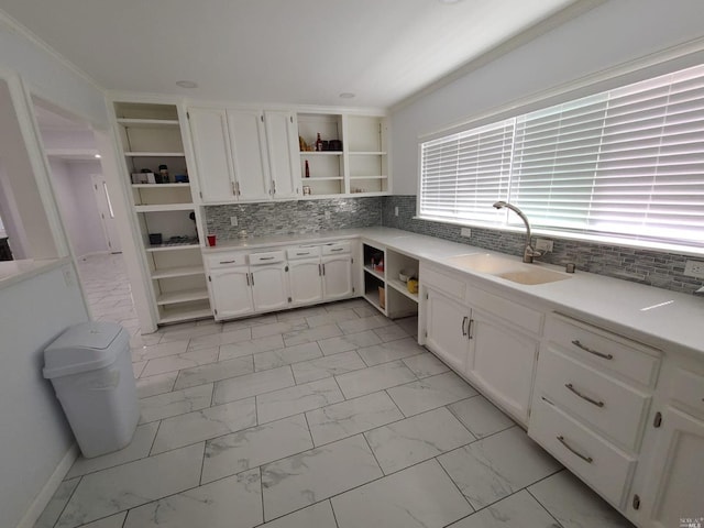 kitchen with light tile flooring, sink, backsplash, and white cabinetry