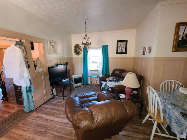 living room featuring cooling unit, wood-type flooring, heating unit, a chandelier, and crown molding