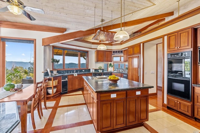 kitchen with black double oven, pendant lighting, ceiling fan, a kitchen island, and light tile flooring