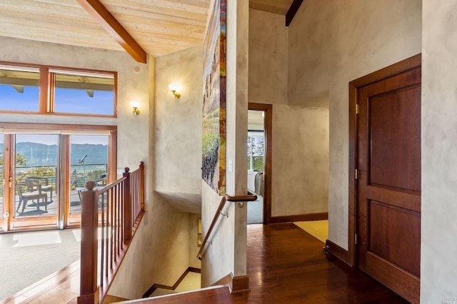 corridor with plenty of natural light, wooden ceiling, dark hardwood / wood-style floors, and beamed ceiling