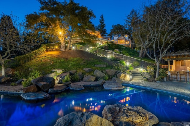 pool at twilight featuring a patio