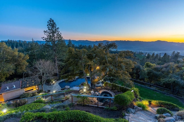 aerial view at dusk featuring a mountain view