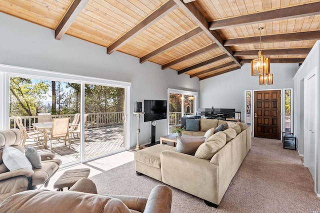 living room with beam ceiling, an inviting chandelier, wooden ceiling, and light colored carpet