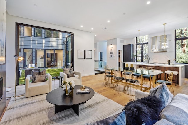 living room with a notable chandelier and light wood-type flooring