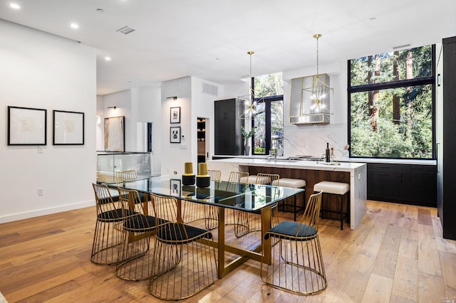 dining space featuring an inviting chandelier and light hardwood / wood-style floors