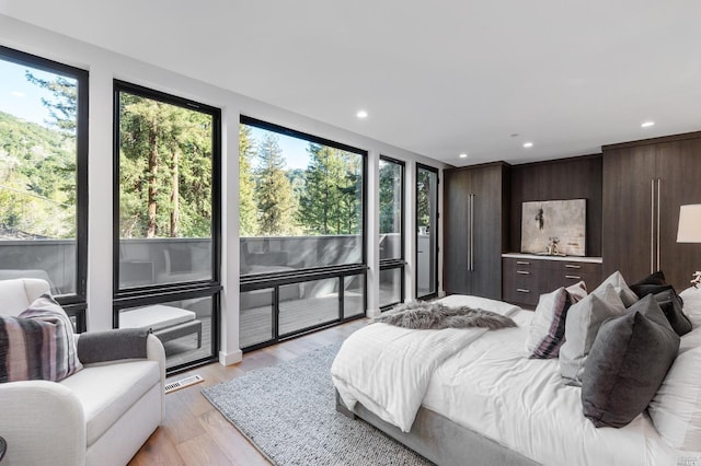 bedroom with multiple windows and light wood-type flooring