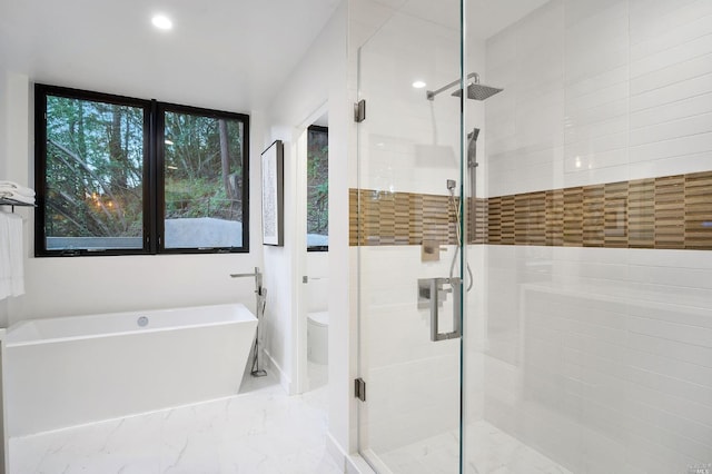 bathroom featuring tile floors, toilet, and separate shower and tub