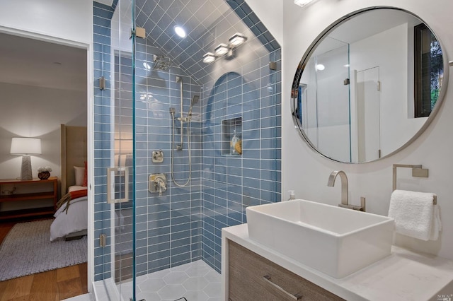 bathroom featuring vanity, hardwood / wood-style floors, and a shower with door