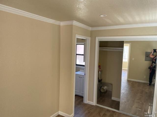 unfurnished bedroom with crown molding, a closet, dark wood-type flooring, and a textured ceiling