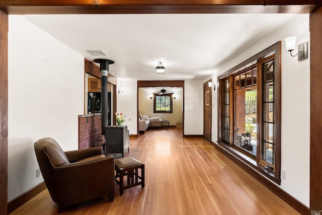 31650 Sherwood Rd, Willits, CA 95490 - living area with a wood stove, light wood-type flooring, visible vents, and baseboards