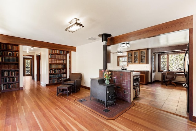 31650 Sherwood Rd, Willits, CA 95490 - living area featuring baseboards, visible vents, built in shelves, wood finished floors, and a wood stove