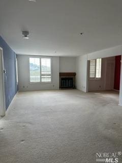 unfurnished living room featuring light colored carpet