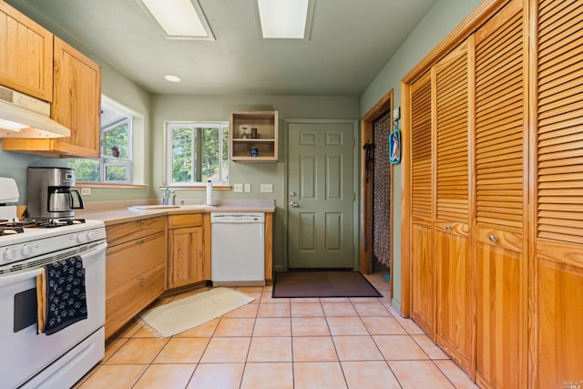 kitchen featuring white appliances, light tile flooring, and sink