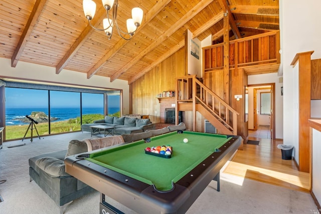 recreation room featuring a chandelier, beamed ceiling, a water view, a fireplace, and wood ceiling