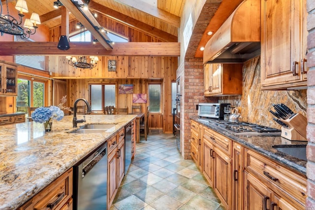 kitchen featuring appliances with stainless steel finishes, beamed ceiling, sink, a chandelier, and light stone countertops