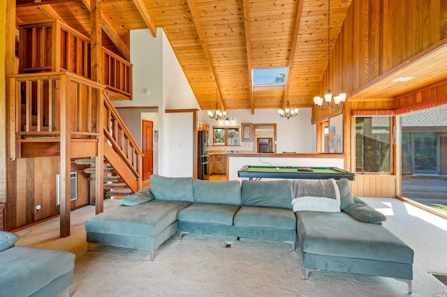 living room featuring a skylight, wooden ceiling, light carpet, high vaulted ceiling, and a notable chandelier