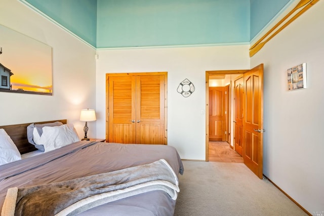 bedroom featuring a towering ceiling, a closet, and light colored carpet