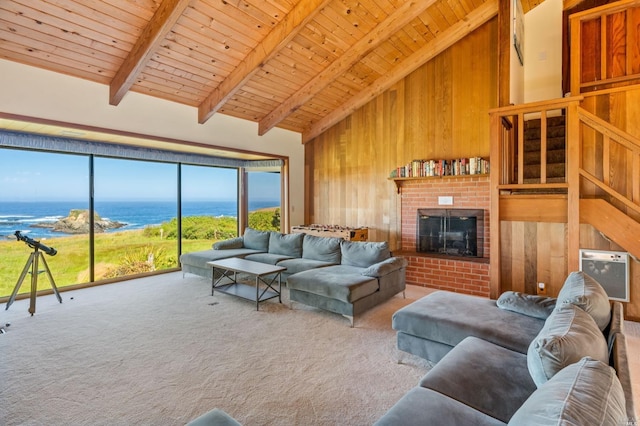 carpeted living room featuring a water view, beam ceiling, a fireplace, and wood walls