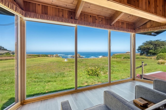 unfurnished sunroom with wooden ceiling, a water view, and lofted ceiling with beams