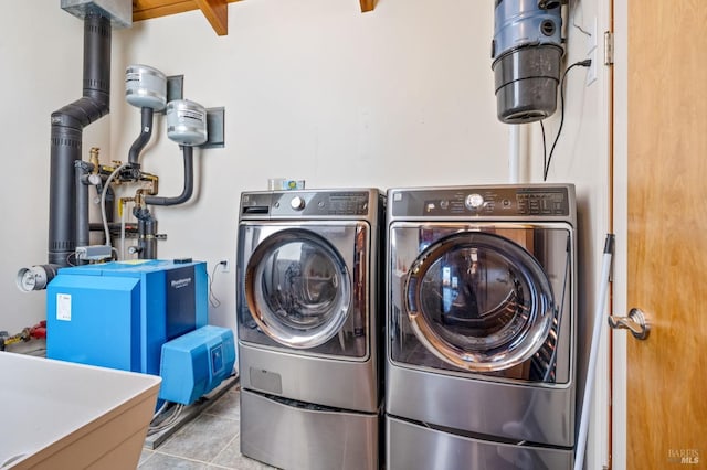 clothes washing area featuring light tile floors, sink, and washing machine and clothes dryer