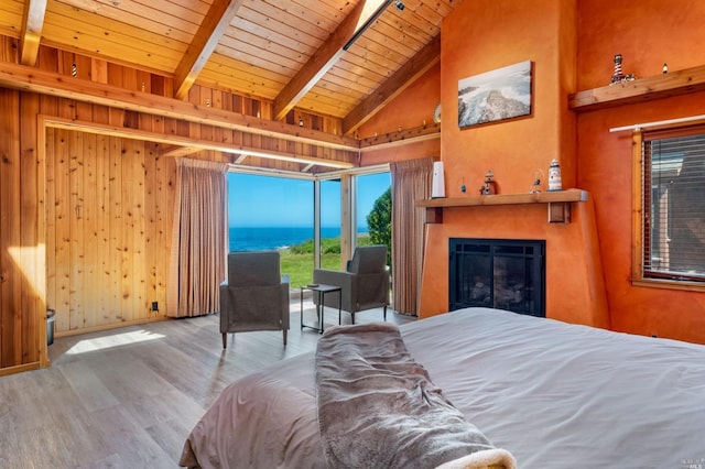 bedroom featuring wood ceiling, beamed ceiling, wooden walls, light hardwood / wood-style flooring, and a water view