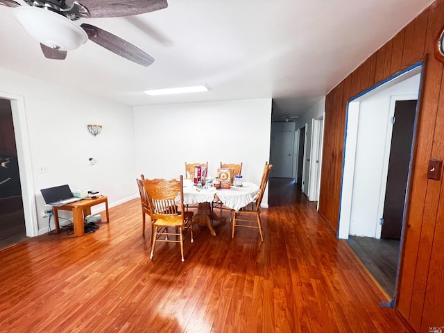 dining space with ceiling fan and dark wood-type flooring