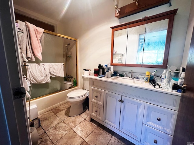 full bathroom featuring tile floors, toilet, vanity, and combined bath / shower with glass door