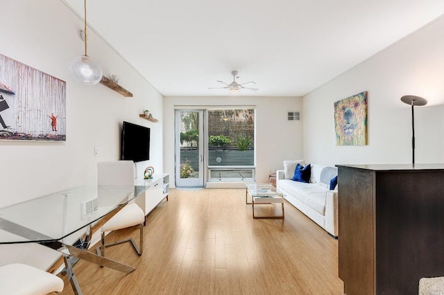 living room with light hardwood / wood-style floors and ceiling fan