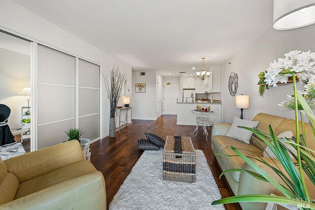 living room featuring a notable chandelier and dark hardwood / wood-style floors