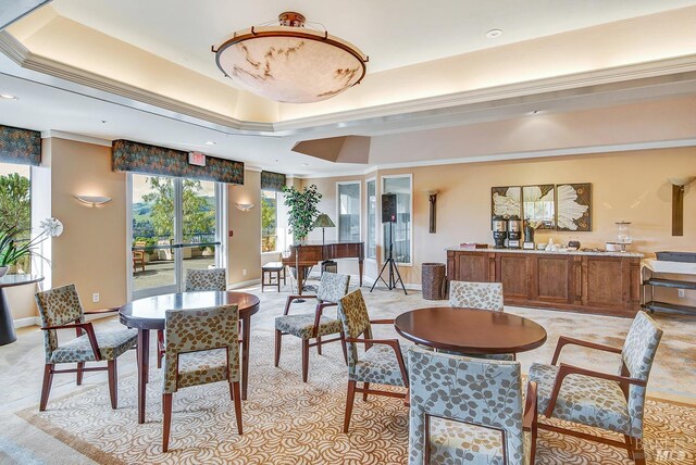 dining space with a tray ceiling and ornamental molding