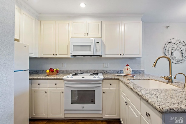 kitchen with white cabinets, white appliances, sink, and light stone countertops