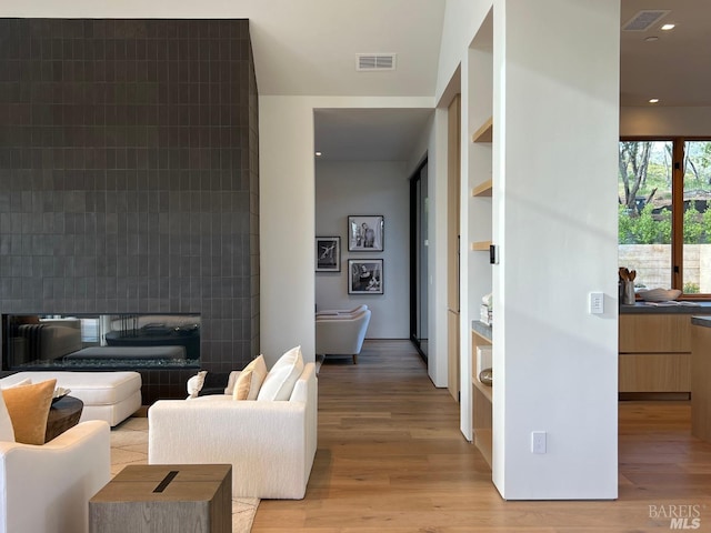 living area featuring light wood finished floors, visible vents, and recessed lighting