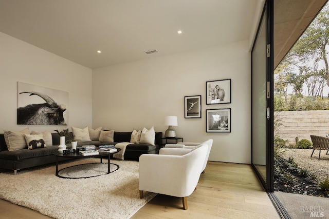 living room featuring light wood finished floors, visible vents, and recessed lighting