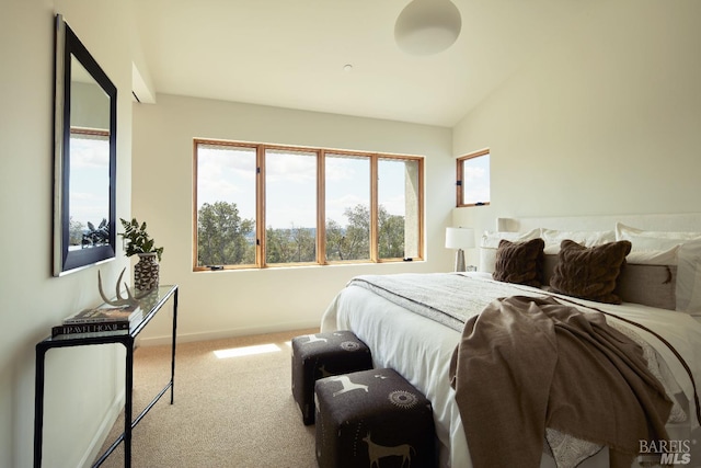 bedroom with carpet floors, baseboards, and lofted ceiling