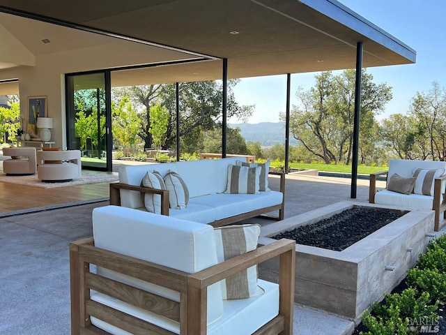 view of patio / terrace featuring a mountain view and an outdoor living space with a fire pit