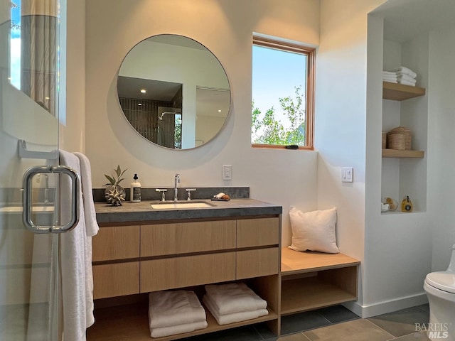 full bathroom featuring a shower stall, baseboards, built in shelves, vanity, and tile patterned flooring