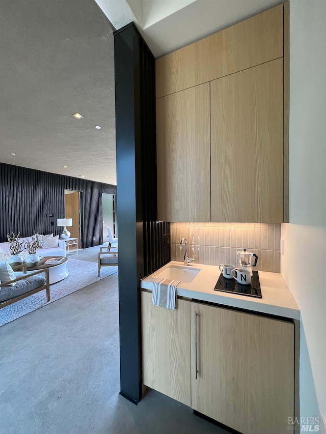 kitchen with modern cabinets, open floor plan, light countertops, and a sink