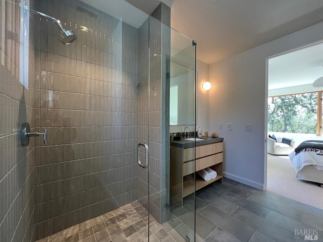 ensuite bathroom featuring baseboards, ensuite bath, a stall shower, and vanity