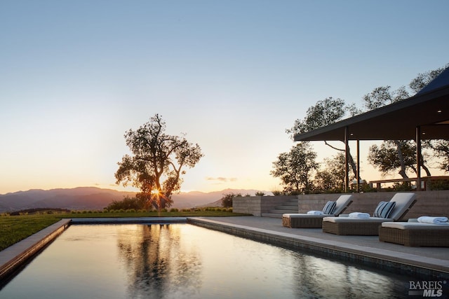 pool with a patio and a mountain view